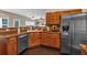 Traditional kitchen with wood cabinets, dark countertops, stainless steel refrigerator, and hardwood floors at 812 Roget Way, Lawrenceville, GA 30045