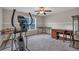 Large open carpeted room featuring a ceiling fan, an exercise machine, and multiple desks at 812 Roget Way, Lawrenceville, GA 30045