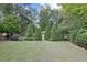 Spacious backyard with lush green lawn and mature trees at 1005 Cromwell Cv, Snellville, GA 30078