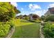 Lush green backyard featuring a well-manicured lawn and garden beds with mature trees and colorful plants at 1005 Cromwell Cv, Snellville, GA 30078