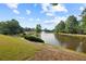 Scenic community lake with a fountain and lush landscaping, surrounded by trees and green space at 1005 Cromwell Cv, Snellville, GA 30078