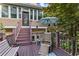 Inviting deck with wooden furniture, steps leading to door, and decorative umbrella providing shade at 1005 Cromwell Cv, Snellville, GA 30078