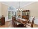 Elegant dining room boasts a large window, a classic chandelier, and a beautiful wood table perfect for formal gatherings at 1005 Cromwell Cv, Snellville, GA 30078