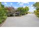 Long driveway leading to a parking area covered by two metal shelters, surrounded by trees and plants at 1005 Cromwell Cv, Snellville, GA 30078