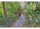 Backyard greenhouse nestled among trees with stone pathway and landscaping at 1005 Cromwell Cv, Snellville, GA 30078