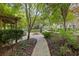 Beautifully landscaped yard with stone walkway, mature trees, and lush greenery at 1005 Cromwell Cv, Snellville, GA 30078