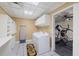 Bright laundry room featuring a modern washer and dryer, storage cabinets, and workout equipment at 1005 Cromwell Cv, Snellville, GA 30078