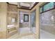 Elegant bathroom featuring a jetted tub, two glass-enclosed showers, and decorative tile at 1005 Cromwell Cv, Snellville, GA 30078