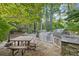 Luxurious outdoor kitchen with stainless grill and stone countertops in a wooded setting at 1005 Cromwell Cv, Snellville, GA 30078