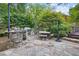Charming outdoor kitchen with stone grill, picnic table, and beautiful stone tilework at 1005 Cromwell Cv, Snellville, GA 30078