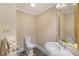 Cozy powder room with pedestal sink, gold-trimmed mirror, and tiled flooring at 1005 Cromwell Cv, Snellville, GA 30078