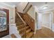 Staircase with wood steps, dark wood railing, and a decorative glass front door at 1005 Cromwell Cv, Snellville, GA 30078