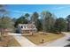 An aerial view displays a home with a long driveway, set back on a large lot with mature trees at 151 River Park Cir, Mcdonough, GA 30252