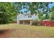 A spacious backyard and patio under the home's awning, surrounded by lush greenery at 151 River Park Cir, Mcdonough, GA 30252