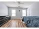 A spacious bedroom featuring wood floors, a ceiling fan, two windows and a dresser at 151 River Park Cir, Mcdonough, GA 30252
