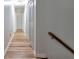 Hallway with wood floors and white walls leading to a door at the end of the corridor at 151 River Park Cir, Mcdonough, GA 30252