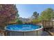 Outdoor swimming pool with wooden deck and ladder, set in a lush backyard landscape at 151 River Park Cir, Mcdonough, GA 30252