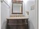 A well-lit powder room with a granite countertop, dark wood vanity, and decorative mirror at 151 River Park Cir, Mcdonough, GA 30252