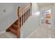 A well-lit staircase with wood railings, leading to the upper level of the home at 151 River Park Cir, Mcdonough, GA 30252