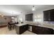 Open concept kitchen with stainless steel appliances, dark cabinets, granite counters, and a view to the dining area at 309 Daffodil Dr, Temple, GA 30179