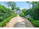 Landscaped backyard featuring a stone pathway, bench, and manicured hedges, creating a serene outdoor space at 67 Delmont Ne Dr, Atlanta, GA 30305
