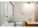 A stacked washer and dryer in the bathroom with stylish light fixture and wooden vanity at 67 Delmont Ne Dr, Atlanta, GA 30305
