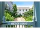 Exterior view through Hedgewood gate, showing the white home with manicured landscaping and inviting pathway at 67 Delmont Ne Dr, Atlanta, GA 30305