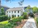 Charming two-story white home with lush landscaping and a convenient covered parking area at 67 Delmont Ne Dr, Atlanta, GA 30305