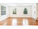 Bright and airy living room featuring hardwood floors, three windows, and minimalist decor at 67 Delmont Ne Dr, Atlanta, GA 30305