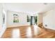 Spacious living room with gleaming hardwood floors, ample natural light, and a glimpse of the staircase at 67 Delmont Ne Dr, Atlanta, GA 30305