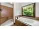 Elegant bathroom featuring a tub, separate shower, and a large window offering ample natural light at 2005 Eagle Rdg, Roswell, GA 30076