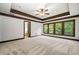 Spacious bedroom featuring a ceiling fan, trim and three large windows offering a view of the lush greenery at 2005 Eagle Rdg, Roswell, GA 30076