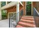 Inviting brick home entrance with steps, black door, and attached garage at 2005 Eagle Rdg, Roswell, GA 30076