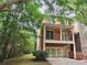 Brick home exterior featuring a two-car garage, upper balcony and lush greenery at 2005 Eagle Rdg, Roswell, GA 30076