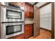 Stainless steel double ovens with wood cabinets and a pantry at 2005 Eagle Rdg, Roswell, GA 30076