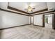 Main bedroom with tray ceiling, carpet, ceiling fan, and multiple doorways at 2005 Eagle Rdg, Roswell, GA 30076