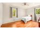 Bright bedroom with hardwood floors, neutral walls, and two windows with views of trees at 3880 Admiral Dr, Chamblee, GA 30341