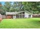 Back exterior of home with large windows, brick accents, and fenced yard at 3880 Admiral Dr, Chamblee, GA 30341