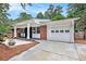 Home's front exterior featuring covered porch, brick facade and garage at 3880 Admiral Dr, Chamblee, GA 30341