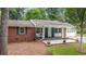 Charming brick home with manicured lawn, covered porch, and attached garage at 3880 Admiral Dr, Chamblee, GA 30341
