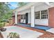 Charming covered front porch with brick columns, ample seating, and brick accents at 3880 Admiral Dr, Chamblee, GA 30341