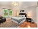 Main bedroom with plush bedding, dark furniture, and large window at 3880 Admiral Dr, Chamblee, GA 30341