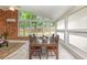 Sunroom with floor to ceiling windows, dining table, wood paneling, and neutral decor at 3880 Admiral Dr, Chamblee, GA 30341