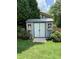 Well-maintained backyard shed with windows and double doors, surrounded by greenery at 158 Delano Dr, Decatur, GA 30032