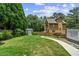 This backyard features a lush lawn, tall trees, a shed and a walkway at 1589 Delano Dr, Decatur, GA 30032