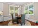 Breakfast nook with round wood table, woven chairs, and modern light fixture at 1589 Delano Dr, Decatur, GA 30032