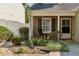 Inviting front porch with beautiful landscaping and a rocking chair at 163 Silver Fox Trail Trl, Dallas, GA 30157