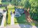 Aerial view of a charming home with a well-manicured front lawn, long driveway, and a detached shed at 2980 Beards Rd, Buford, GA 30518