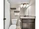 Clean bathroom featuring a toilet, sink, and vanity with granite countertops, plus a shower with a white curtain at 2980 Beards Rd, Buford, GA 30518