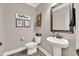 Elegant powder room with pedestal sink, modern fixtures, and stylish decorative accents at 2980 Beards Rd, Buford, GA 30518